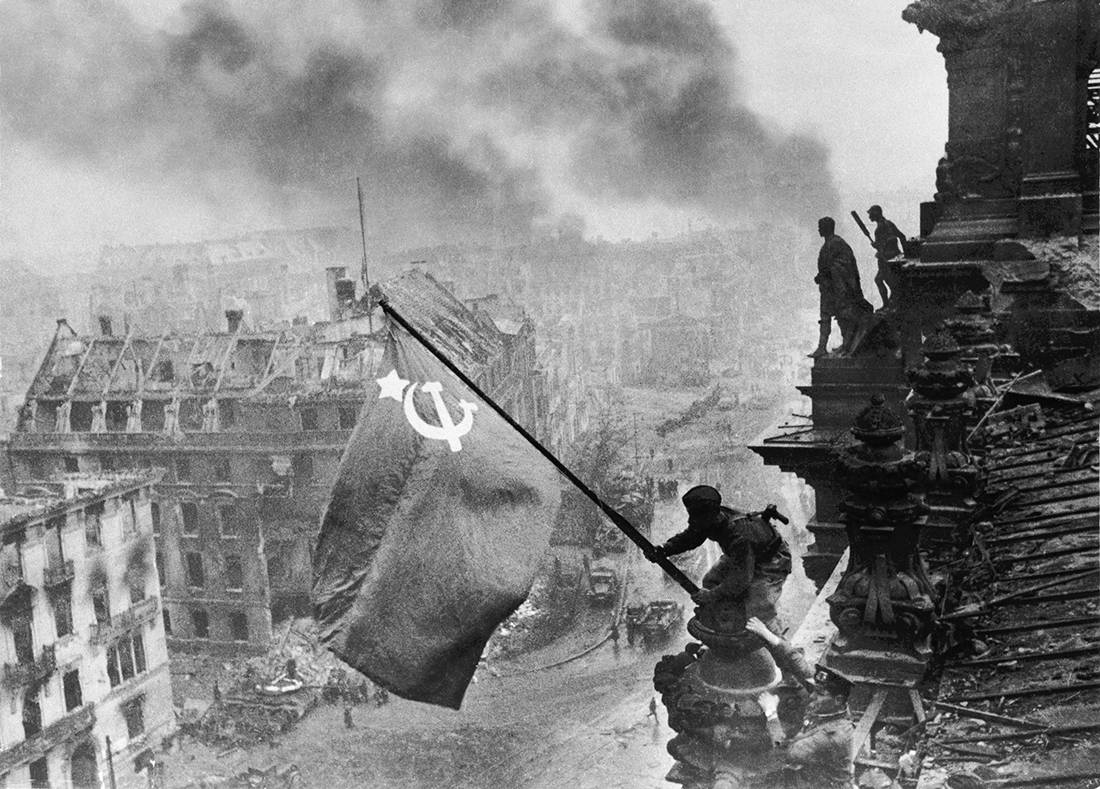 02 May 1945, Berlin, Germany --- A soldier raises the Soviet flag over the Reichstag during the fall of Germany and the Third Reich. --- Image by © Yevgeny Khaldei/Corbis